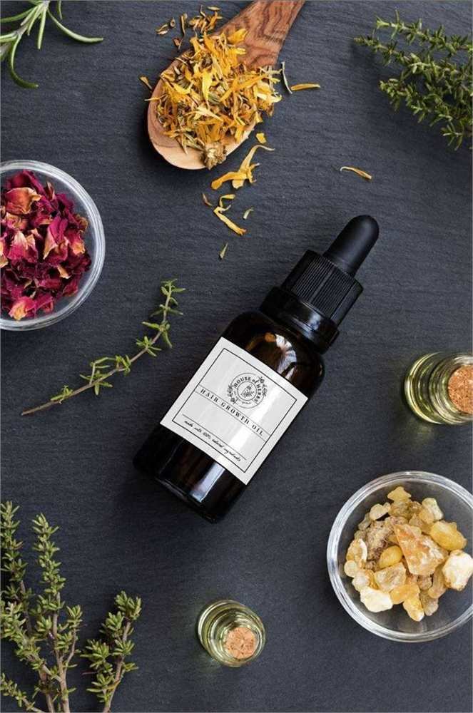 House of Herbs Hair Growth Oil bottle styled with botanicals on a dark premium surface.